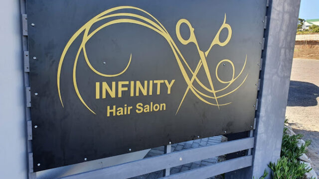 The outside signage board of Infinity Hair Salon in Langebaan, showing name in gold letters and scissors