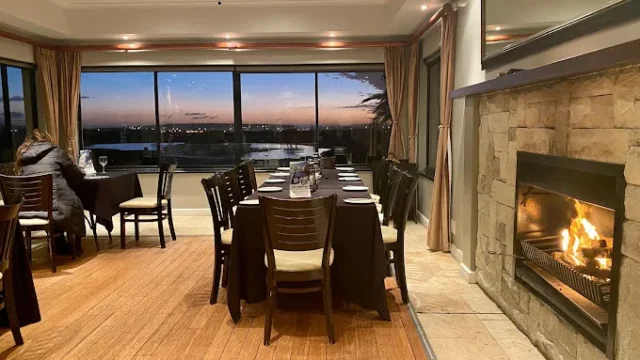 The Horizon Restaurant in Langebaan in the Country Estate with upmarket furniture, wooden floor, fireplace and view over langebaan at night.