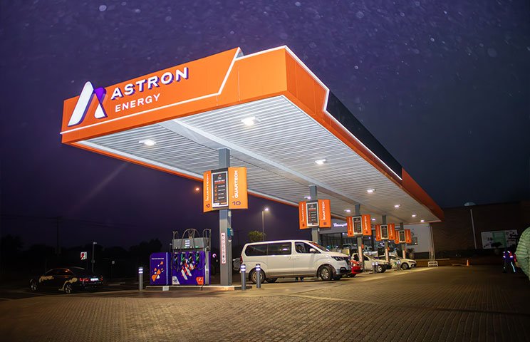 The Astron Energy Petrol Station in Langebaan at night with orange branded colour and signage in white.