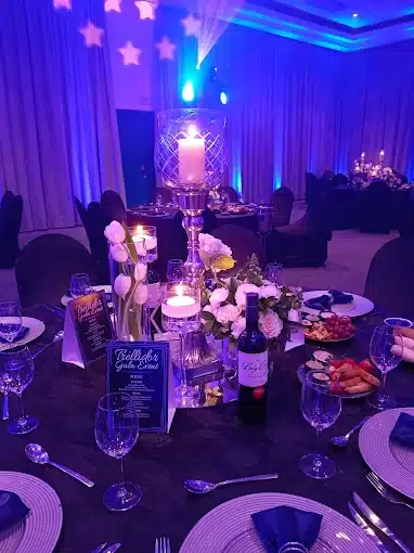 Privat function at night with decirated round tables, flowers, candles and cultlery display on tables at the athene Conference Centre in Langebaan for weddings.