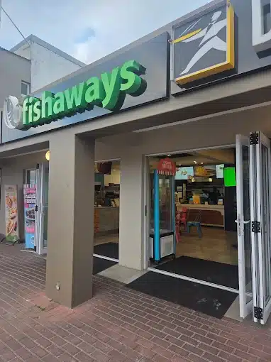 The entrance to Fishaways in Langebaan with green signage on the outside and a view inside of serving counter.