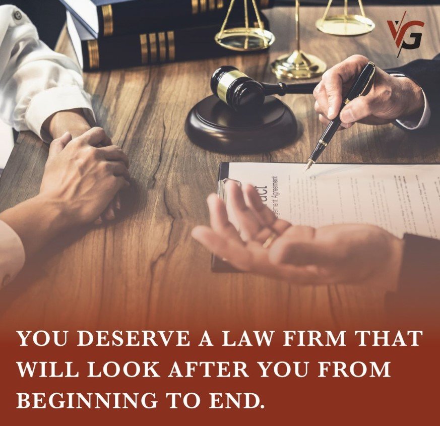 Two men around a table discussing legal issues with pen and paper at Geldenhuys Jonker Attorneys in Langebaan.