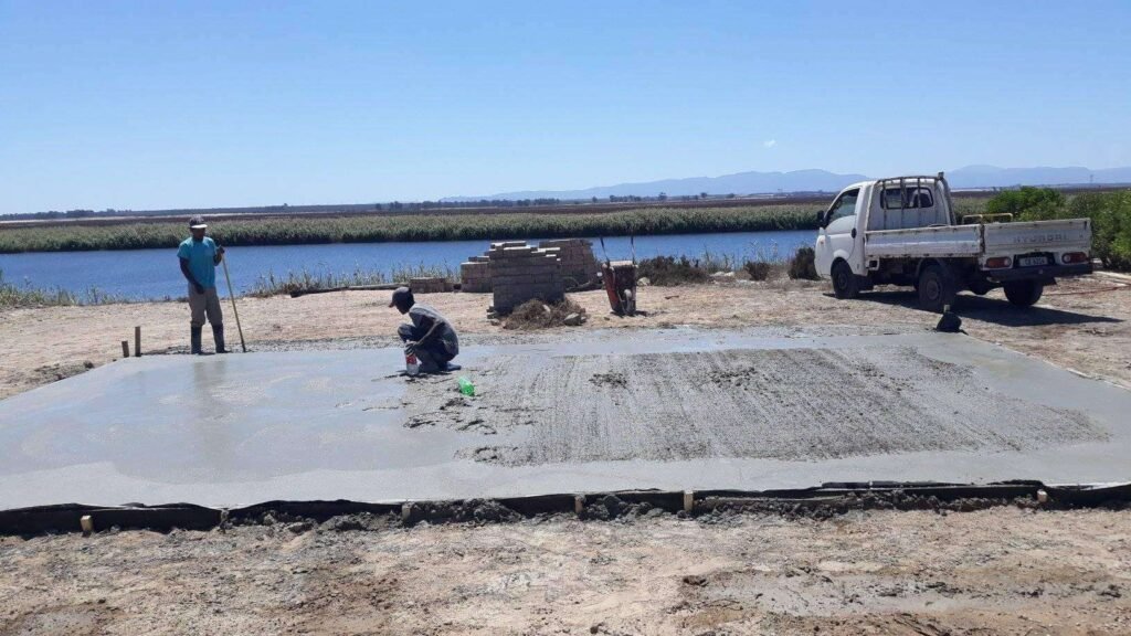 Workers of Laguna Wendys in Langebaan are attending to the cement foundation of a wendy house next to a river.
