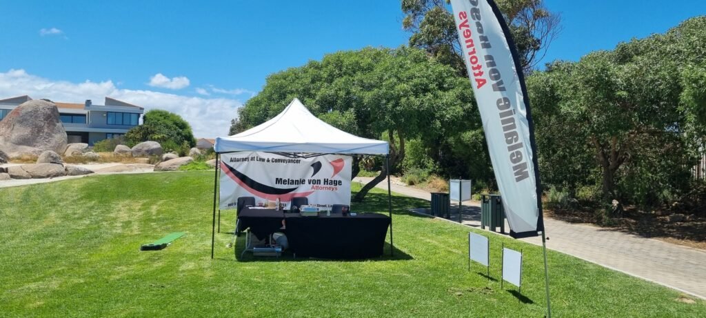 Promotional tent and banners on the golf course for Melanie von Hage Attorneys in Langebaan with black and ppink colours on white.