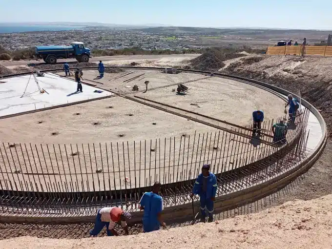Workers working with steel and concrete as they build a water store facility by Siroccon International in Langebaan