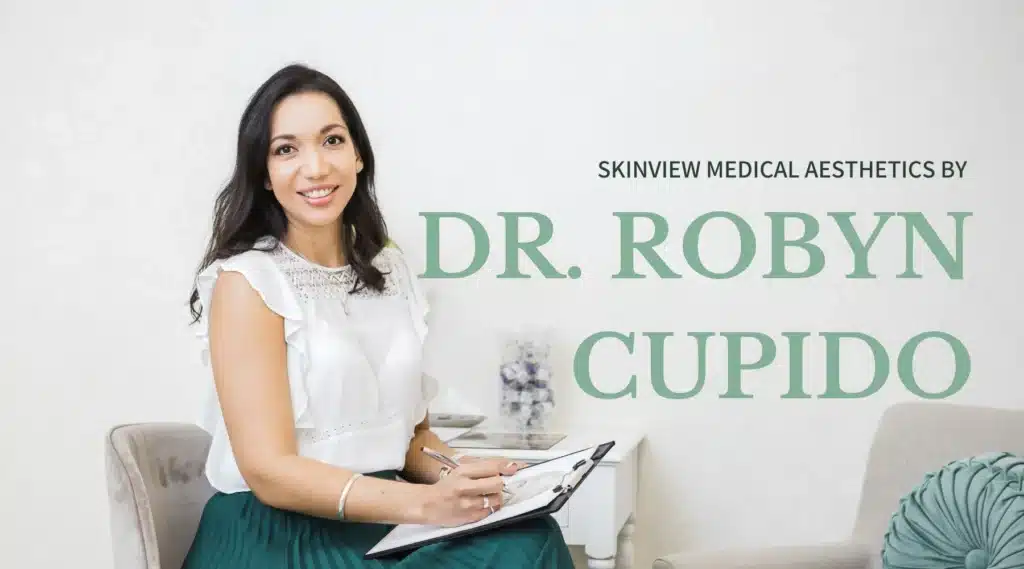 A Picture of Dr Robyn Cupido sitting down with pen and paper in hand, at the Skinview Medical Aesthetics in Langebaan.