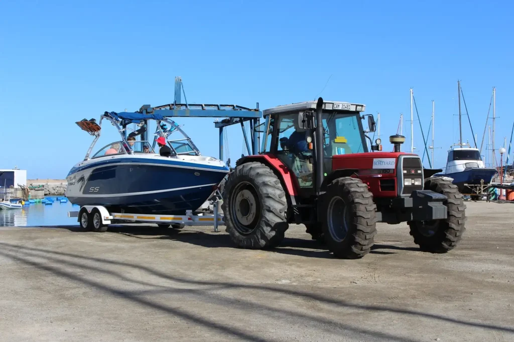 A Tractor by The Langebaan Boatyard is busy launching a boat as a service at the marina at Club Mykonos Langebaan.