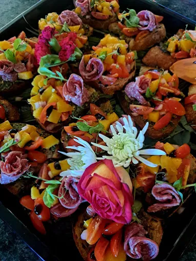 Beautifully display of food snacks with flowers as decorations on the platter provided by Boeretroos Langebaan Catering Services.