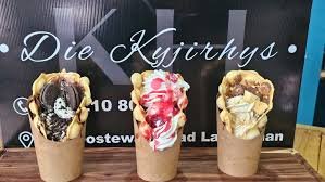 Differnet flavours of icecream in a cone diplayed on a table with dark logo at the background of Die Kyjirhys Coffee Shop in Langebaan.