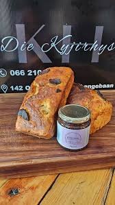 Home baked treats with home made jams on display with dark logo in background of Die Kyjirhys in Langebaan.