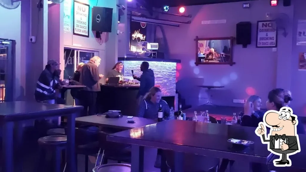 DJ on stage for entertainment at Die Watergat Langebaan, proving live music for people sitting at tables at night.