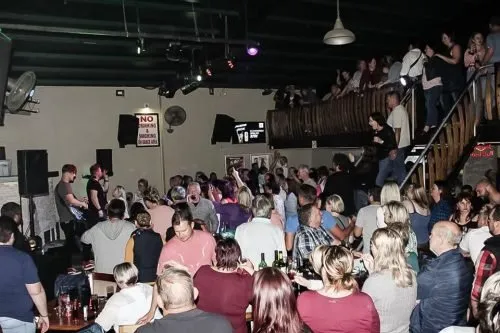 A very big crowd inside Die Watergat Langebaan enjoying life music by the band on stage while dancing an dhaving a good time at night.