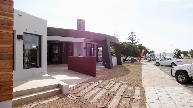 The entrance to Windtown Hotel and Breeze Restaurant in Langebaan with paved payment, tiled steps and wooden finishings.