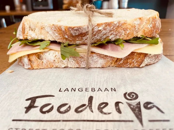 Home made brea with meat and cheese, tied with a string on brown paper by Fooderia Langebaan Coffee Shop and Juice Bar.