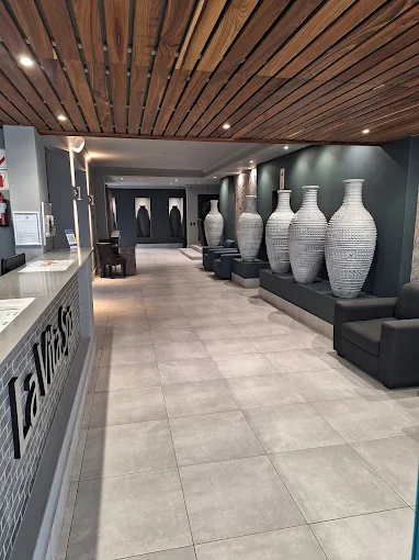 The entrance to La Vita Spa in Langebaan with tiled floors, wooden ceilings and row of white pots on display along the alley from reception desk to treatment rooms.