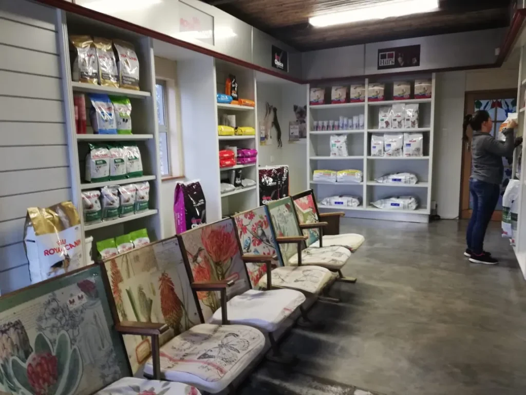 The interior of Langebaan Animal Hospital with merchandise on the shelves against the wall and seating in flower fabric in a row