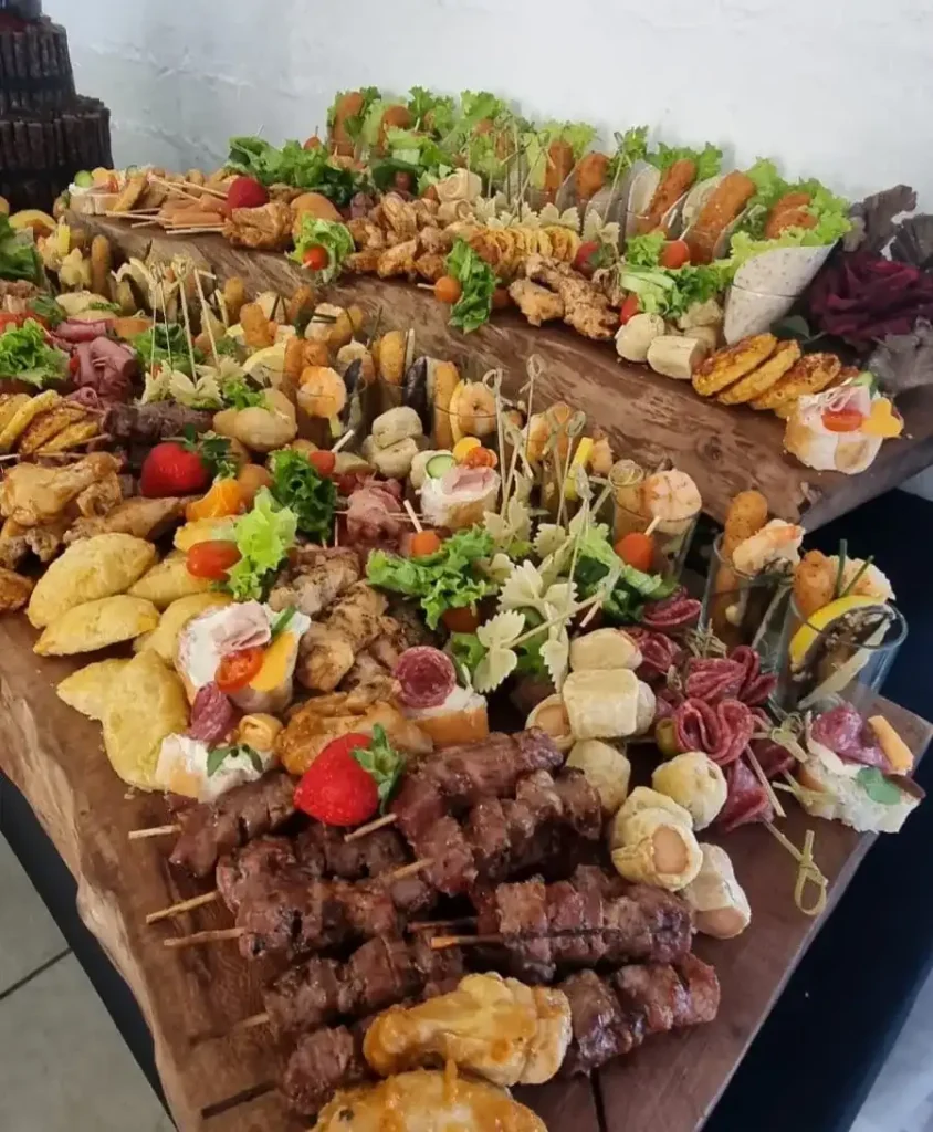 Wooden table with a variety of meat and food on display at a function by Langebaan Spitbraai, Catering and Decor in Langebaan.
