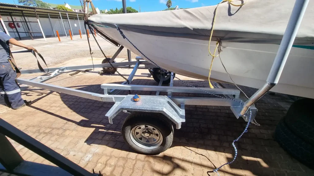 A Boat covered with a sail on a trailer at Langbeaan Trailer & Boatyard in Langebaan, where you find storage facilities for boats, repair and hire options for trailers.