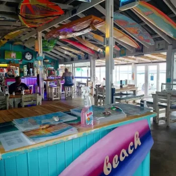 Colourful interior with pastel colours on the ceiling and with surfboards, sails and counters at Marc's Beach Bar in Langebaan.