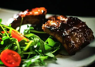 Quality food on a white playte that consist of grilled steak, greens and tomatoes at Marc's Beach Bar in Langebaan