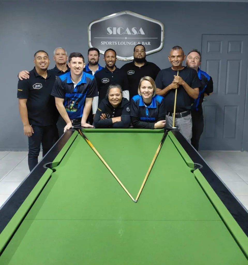 A Group photo of pool players in front of green pool table with sticks at SiCasa Sports Lounge & Bar in Langebaan