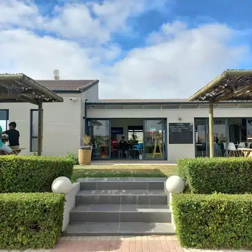 Steps towards Soldato Cafe in Langebaan with landscape terraces and wooden shade poles for outside seating on the golf course at this Coffee Shop.
