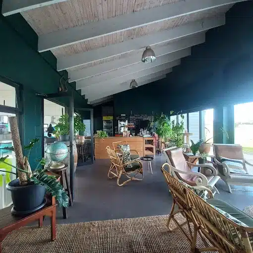 The green walls and wooden furniture with white ceilings of Soldato Cafe in Langebaan as a Coffee Shop.
