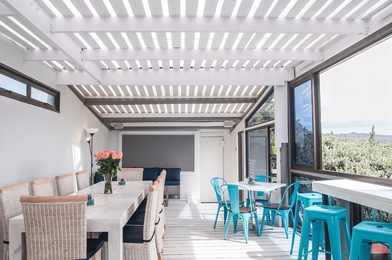 Th interior of Wunderbr in Langebaan with white floors, canopy, tables and teal chairs.